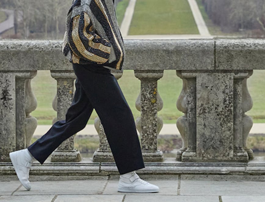 person walking clothing footwear shoe pants sneaker accessories bag handbag